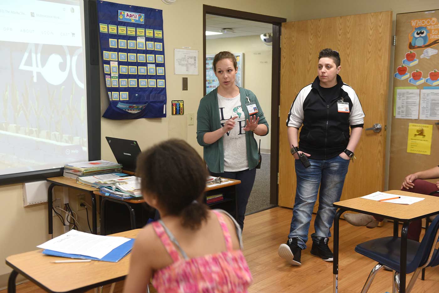 Two Natchaug teachers talk to students in the front of a classroom