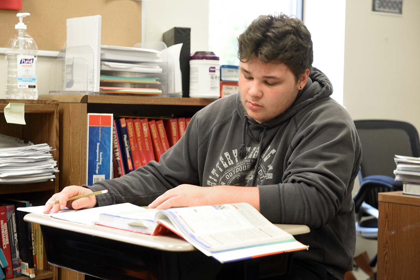 Natchaug student reads a textbook and takes notes