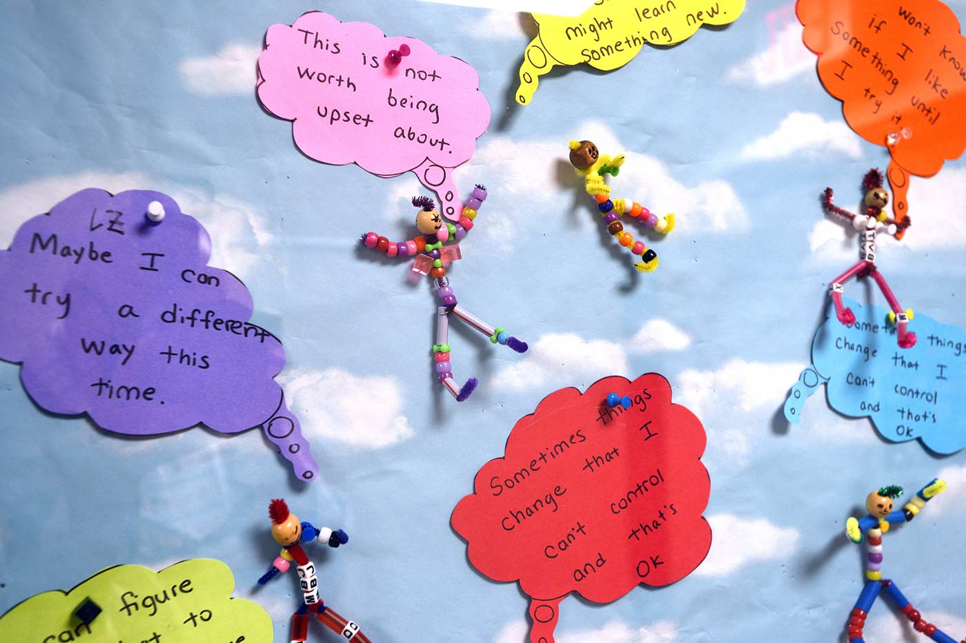 Natchaug student art with colorful emotional coping methods written out among pipe cleaner dolls made with plastic beads
